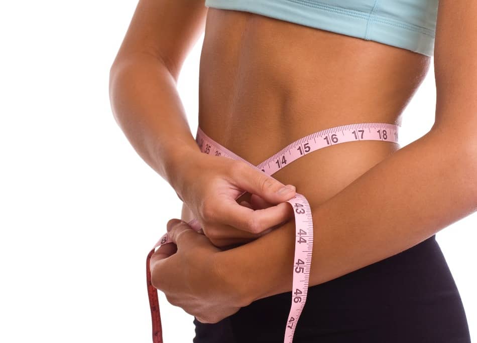 A woman measuring her waistline. 